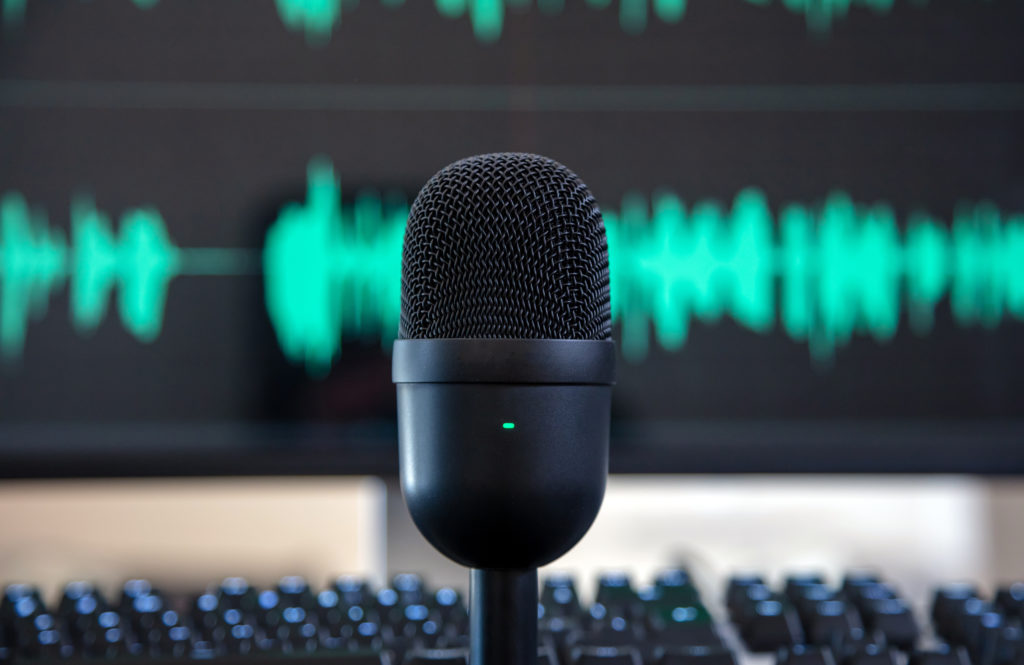 Sound recording concept. Condenser microphone, blur console and turquoise waveform background. Mike for live audio, music, speech, concert, performance, Close up view.